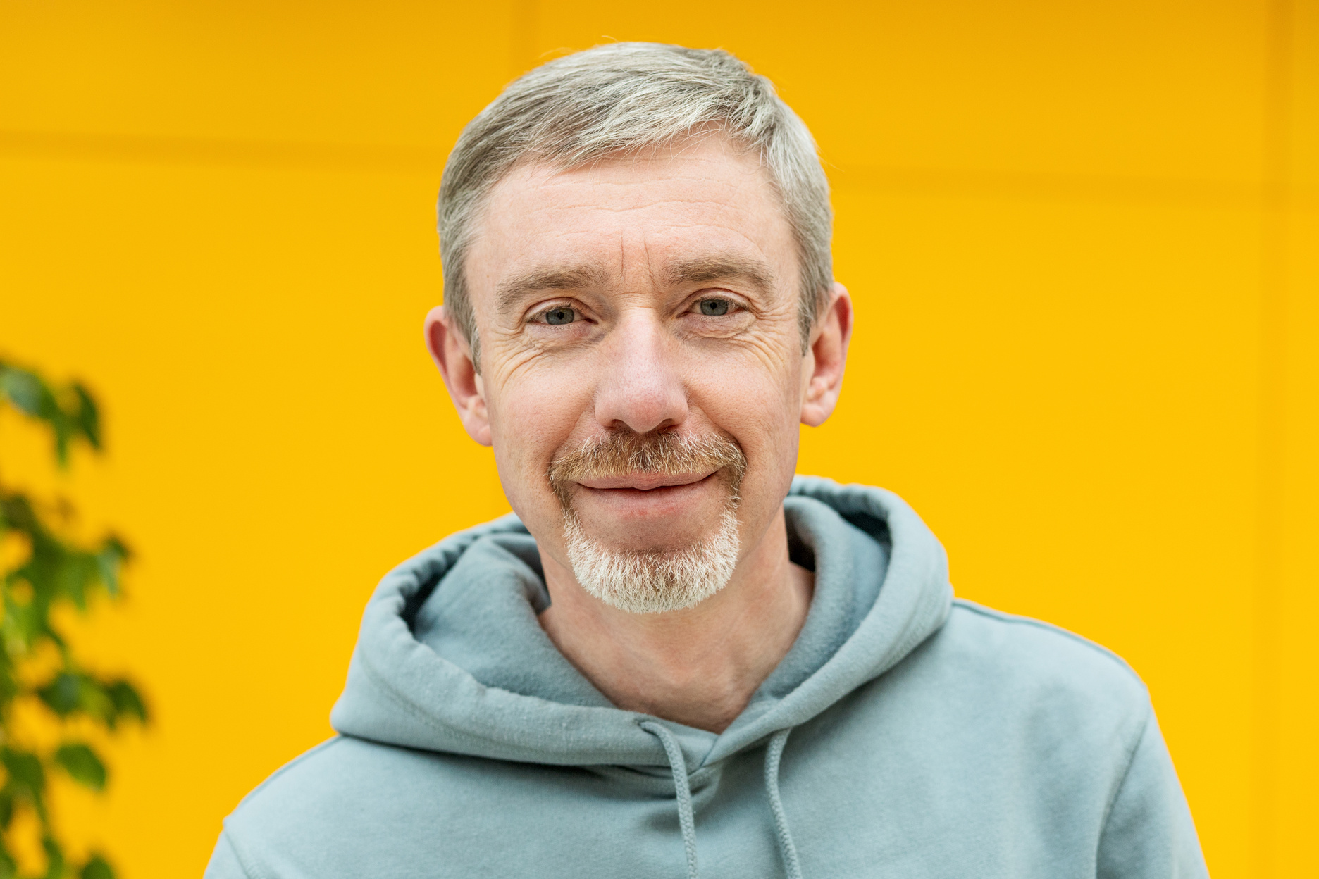 Close up portrait of happy 50 year old white bearded man in hooded shirt